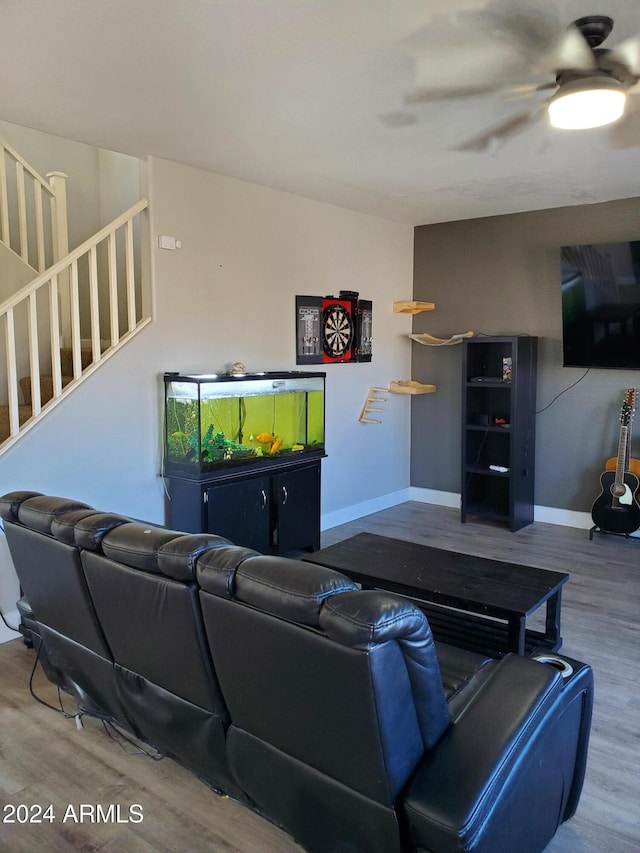 living room featuring wood-type flooring and ceiling fan