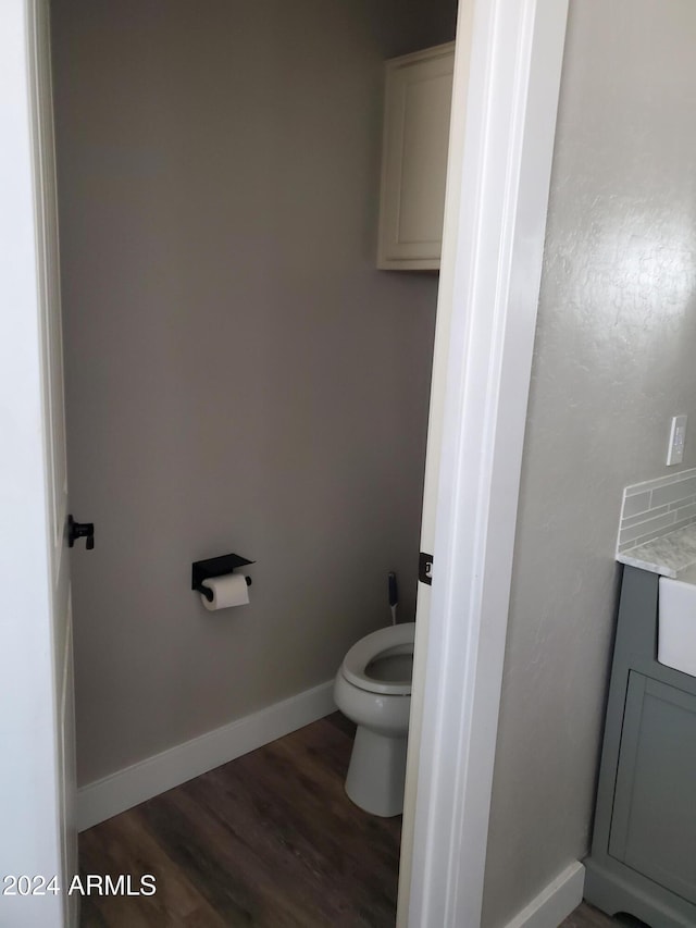 bathroom with toilet and wood-type flooring