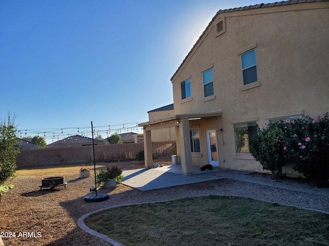 back of house with a lawn and a patio area