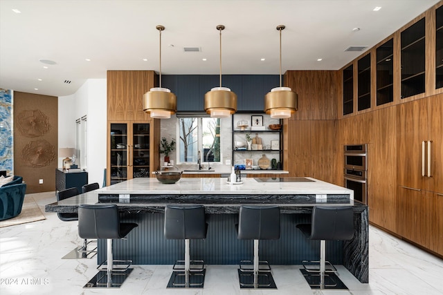 kitchen with a kitchen bar, sink, wooden walls, and a large island