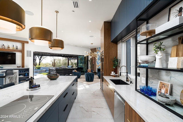 kitchen with cooktop, sink, dishwasher, pendant lighting, and light stone countertops