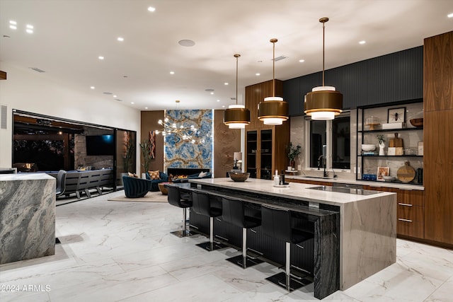 kitchen with pendant lighting, sink, a spacious island, light stone countertops, and a kitchen bar