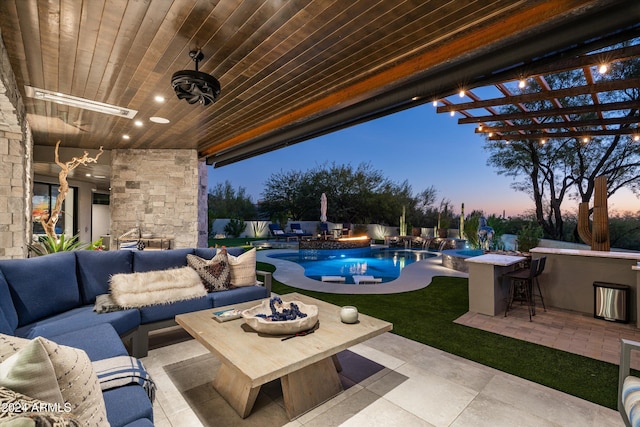 patio terrace at dusk with pool water feature, an outdoor living space, and exterior bar