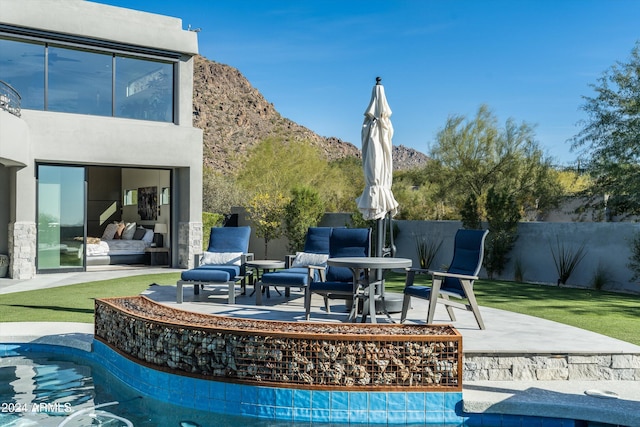 view of pool featuring a patio, a mountain view, and a yard