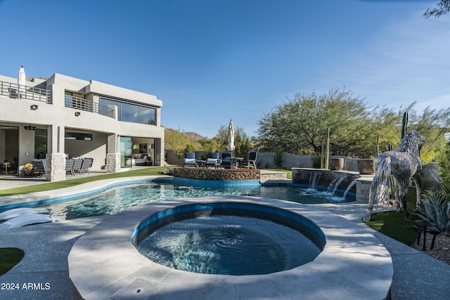 view of swimming pool featuring an in ground hot tub, pool water feature, and a patio