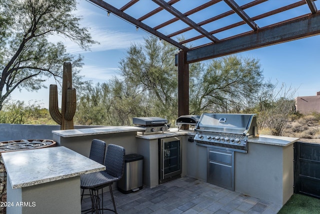 view of patio with a pergola, wine cooler, a grill, a bar, and exterior kitchen