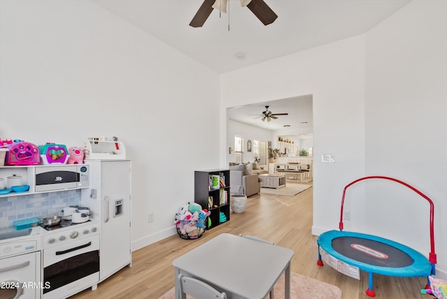 rec room with light wood-type flooring and ceiling fan