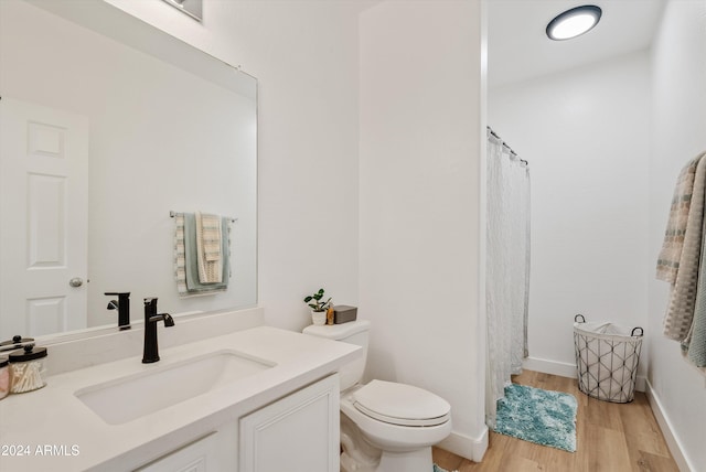 bathroom featuring vanity, hardwood / wood-style flooring, and toilet