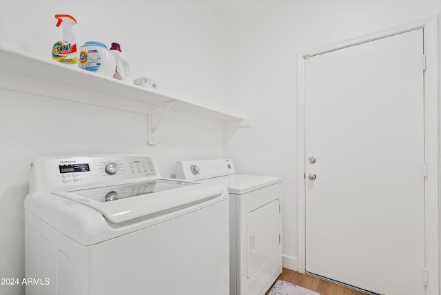 laundry area with light hardwood / wood-style flooring and washer and clothes dryer