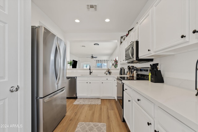 kitchen with white cabinets, sink, ceiling fan, light wood-type flooring, and appliances with stainless steel finishes