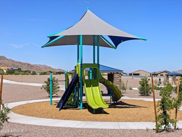 community play area featuring a mountain view and fence