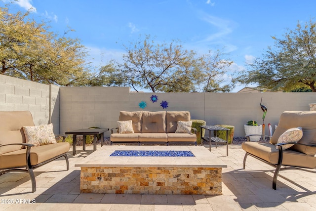 view of patio with an outdoor living space with a fire pit