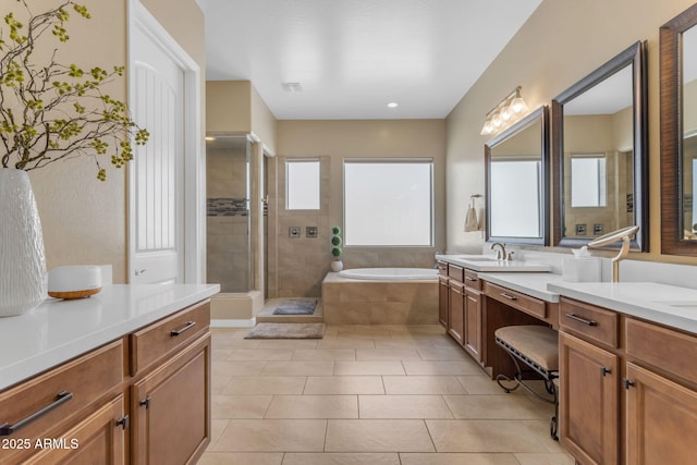 bathroom with tile patterned floors, plenty of natural light, independent shower and bath, and vanity