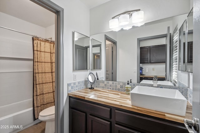 full bathroom with toilet, tasteful backsplash, vanity, and shower / tub combo with curtain