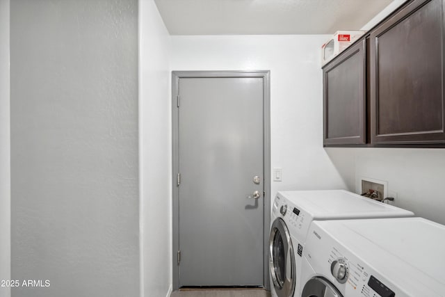 laundry area with separate washer and dryer and cabinets