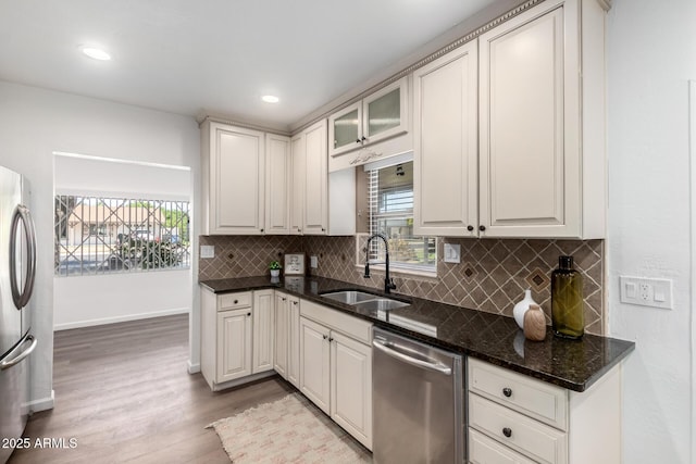 48 S Catalina St, Gilbert, AZ 85233 - kitchen featuring stainless steel appliances, wood finished floors, backsplash, dark stone countertops, and glass insert cabinets