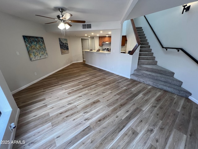 unfurnished living room featuring ceiling fan and light wood-type flooring