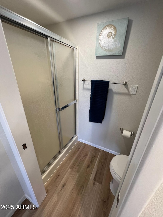 bathroom featuring hardwood / wood-style floors, toilet, and walk in shower