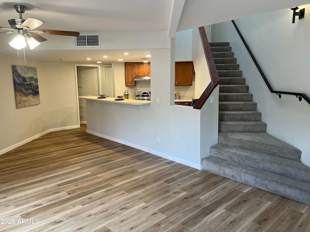 unfurnished living room featuring wood-type flooring and ceiling fan