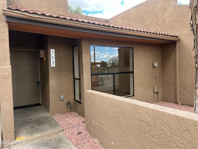 view of exterior entry with a balcony