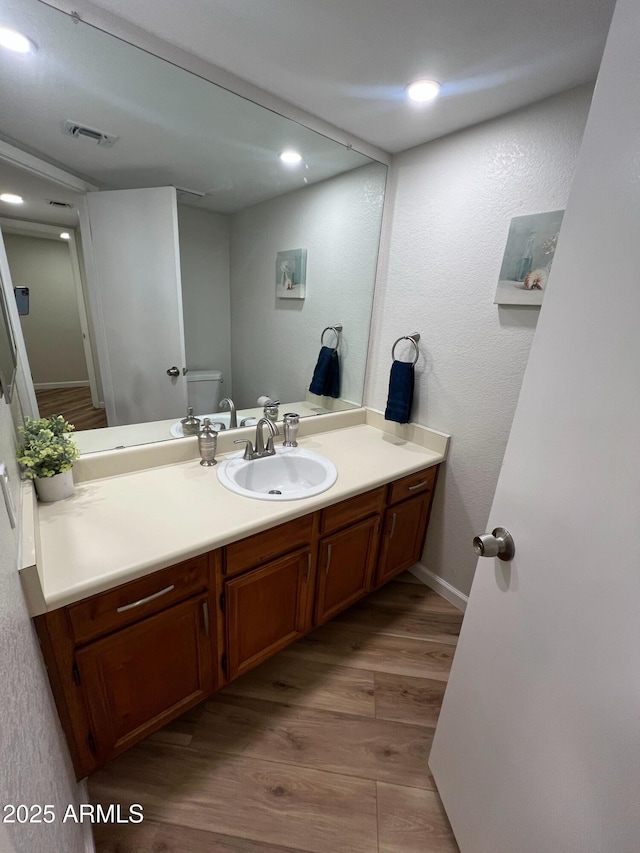 bathroom featuring vanity, toilet, and hardwood / wood-style floors