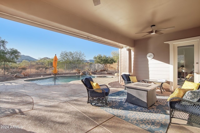 view of patio / terrace with pool water feature, ceiling fan, a fenced in pool, and a mountain view