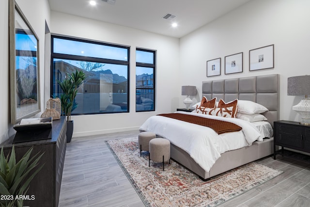 bedroom with light wood-type flooring, baseboards, and visible vents