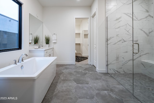 full bath featuring vanity, baseboards, a stall shower, a freestanding bath, and a spacious closet