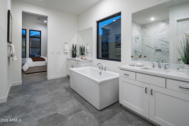 ensuite bathroom with connected bathroom, vanity, baseboards, and a freestanding tub