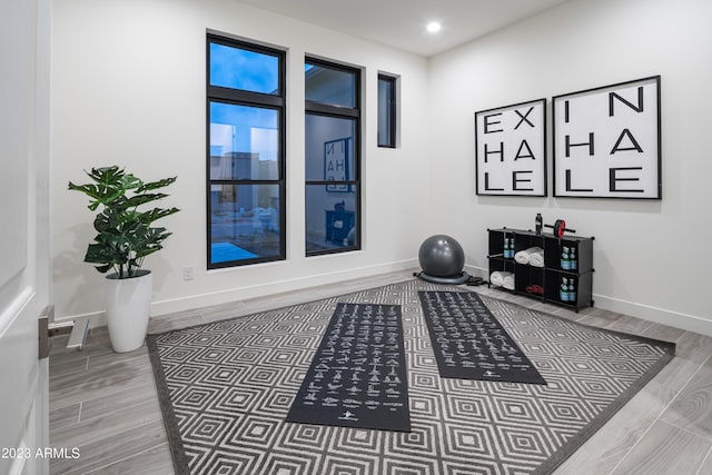 exercise area with wood finish floors, baseboards, and recessed lighting