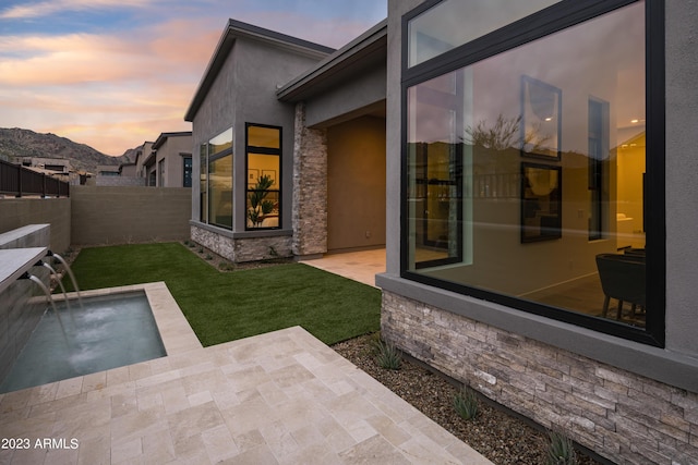 exterior space featuring a mountain view, fence, and a patio area