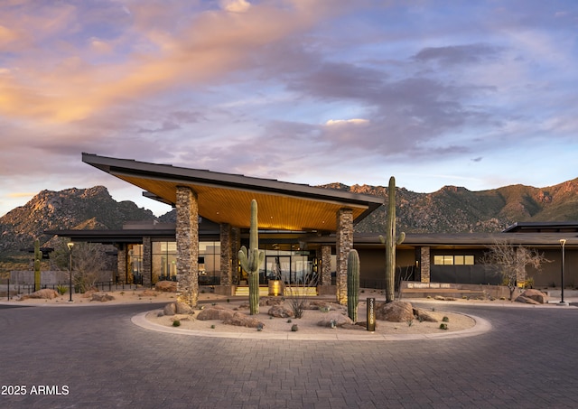 exterior space featuring a mountain view, curved driveway, and fence