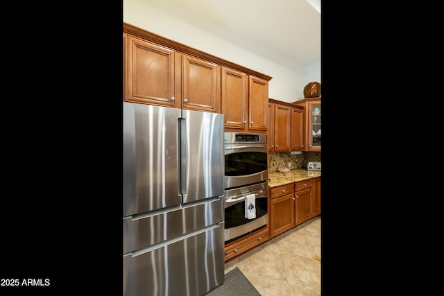 4229 E Nightingale Ln, Gilbert, AZ 85298 - kitchen with stainless steel appliances, brown cabinets, light stone counters, and backsplash