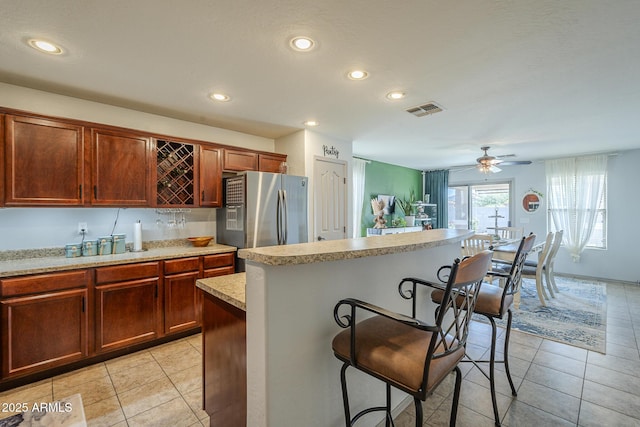 25930 N 165th Ln, Surprise, AZ 85387 - kitchen with freestanding refrigerator, a breakfast bar area, light countertops, light tile patterned flooring, and recessed lighting