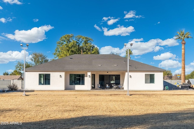 rear view of house featuring a patio and a yard