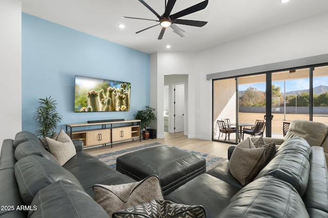 living room with ceiling fan and light hardwood / wood-style flooring