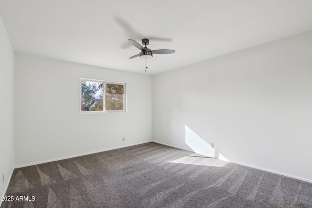 empty room with ceiling fan and dark carpet