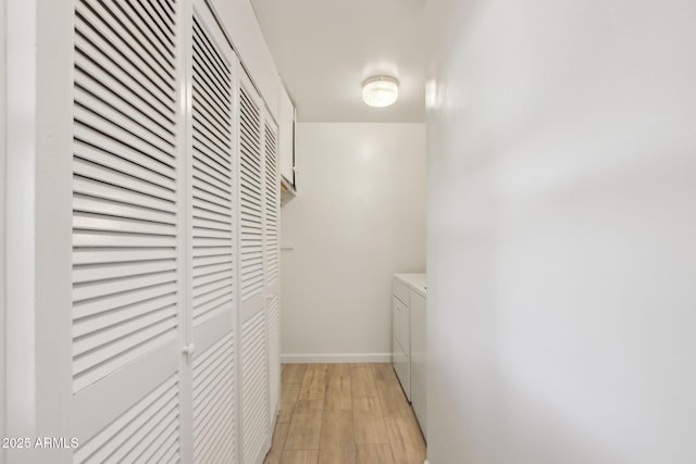 corridor featuring light wood-type flooring and washing machine and clothes dryer