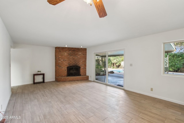 unfurnished living room featuring ceiling fan, a fireplace, and light hardwood / wood-style floors