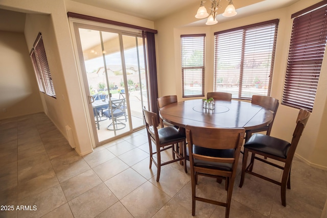dining area with baseboards and an inviting chandelier