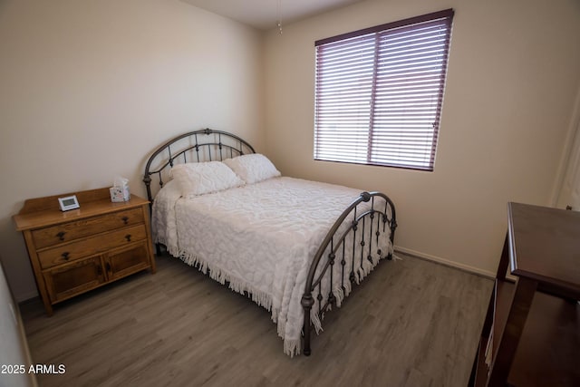 bedroom featuring baseboards and wood finished floors