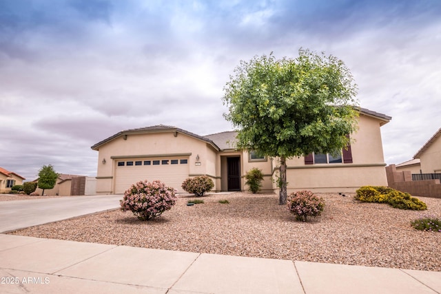 ranch-style house featuring driveway, stucco siding, a garage, and fence