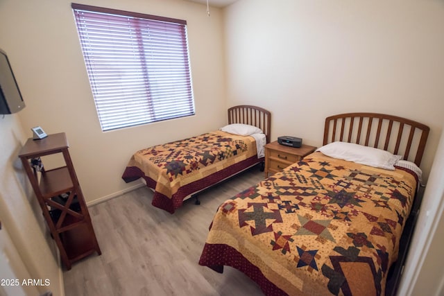 bedroom featuring baseboards and wood finished floors