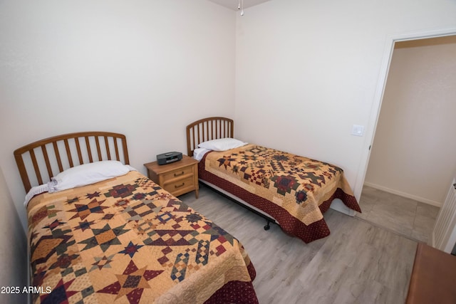 bedroom featuring baseboards and wood finished floors
