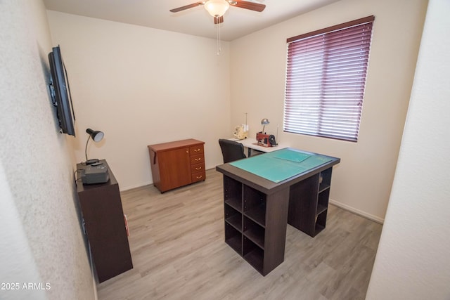 office area with light wood finished floors, baseboards, and a ceiling fan