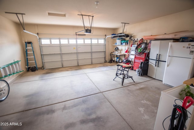 garage with freestanding refrigerator and a garage door opener