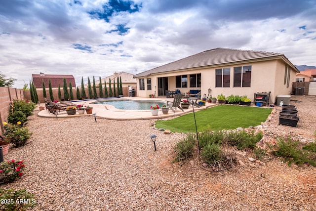 rear view of house with a fenced in pool, a patio area, stucco siding, a tile roof, and a fenced backyard