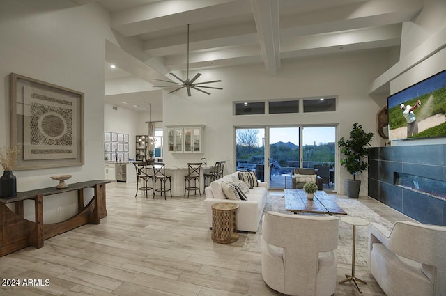 30600 N Pima Rd Unit 49, Scottsdale, AZ 85266 - living area with beam ceiling, light wood-style flooring, a high ceiling, ceiling fan, and a tiled fireplace
