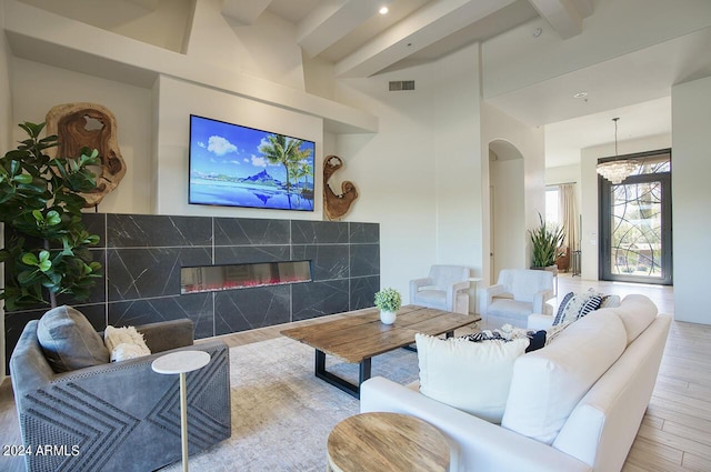 30600 N Pima Rd Unit 49, Scottsdale, AZ 85266 - living area featuring a high end fireplace, visible vents, beam ceiling, wood finished floors, and arched walkways
