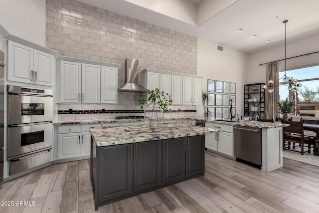 30600 N Pima Rd Unit 49, Scottsdale, AZ 85266 - kitchen featuring a warming drawer, stainless steel appliances, white cabinets, and wall chimney range hood